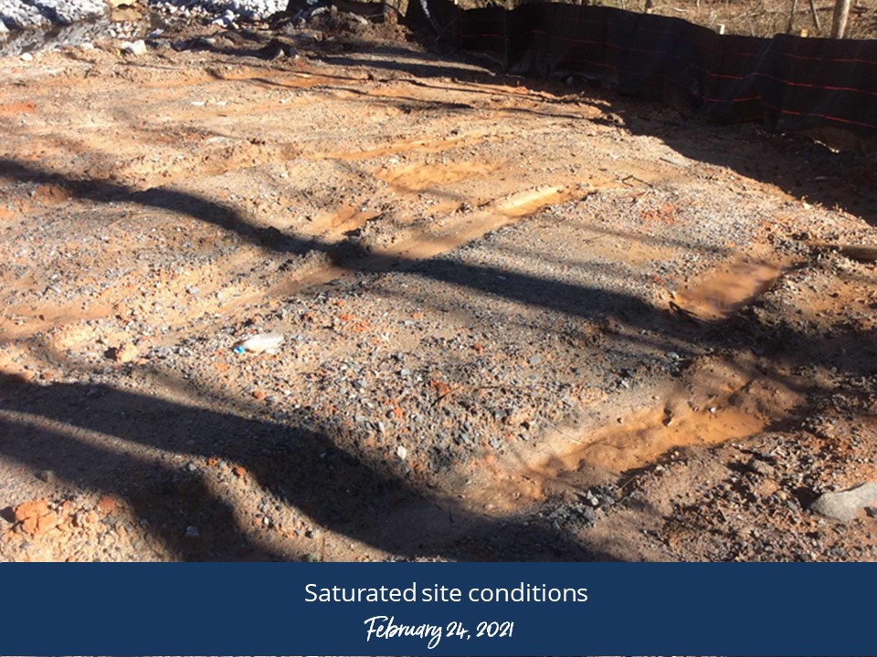 A dirt patch covered with a blue tarp, indicating a temporary or protected area